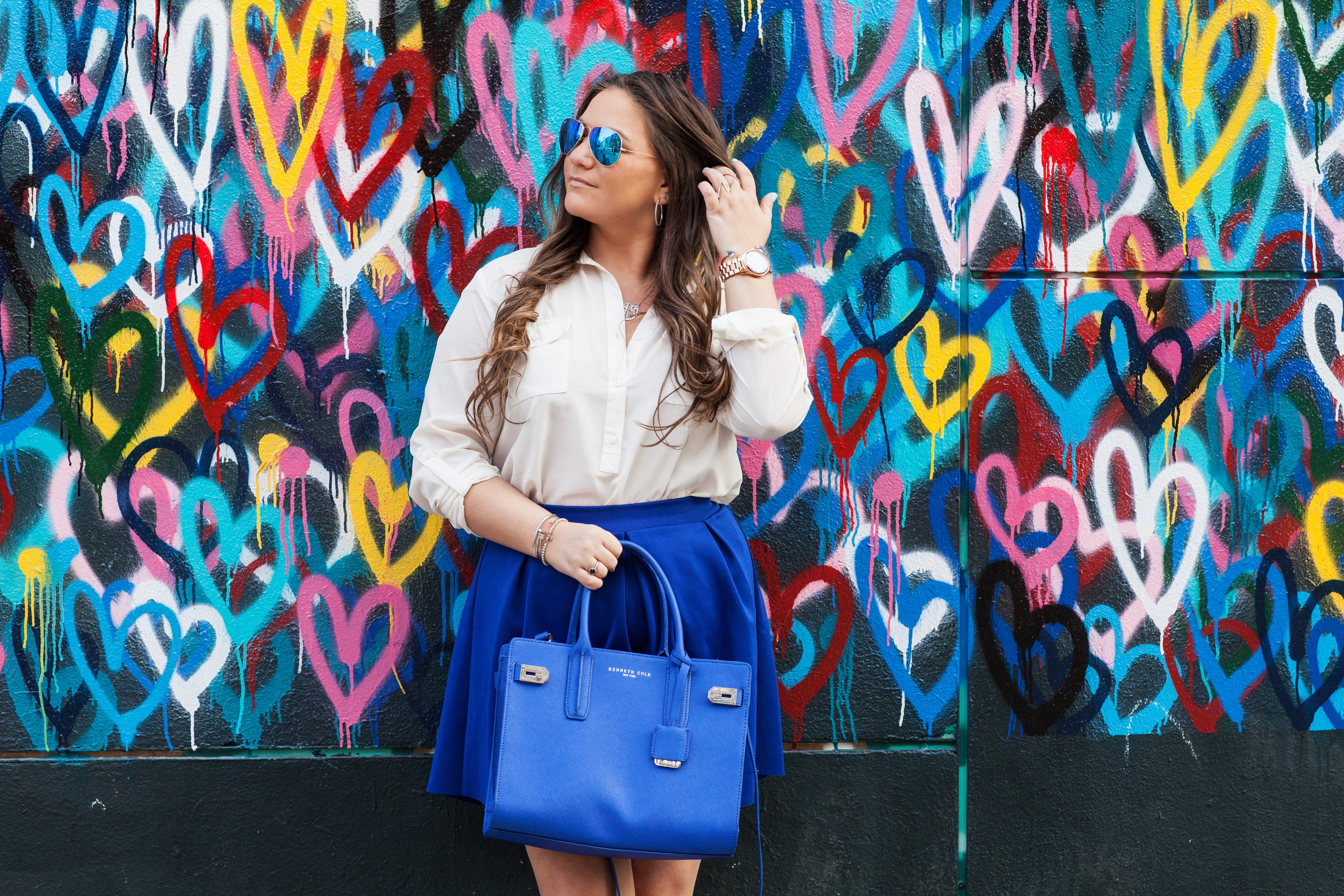melissatierney, missyonmadison, nyc, heartwall, lovewall, graffitiart, graffiti, blueskirt, whitebuttondown, bluesatchel, mirroredaviators, whiteanklestrapsandals, raybans, springstyle, spring, streetstyle, ootd, outfitinspo, springcolors, what to wear to work in the spring,