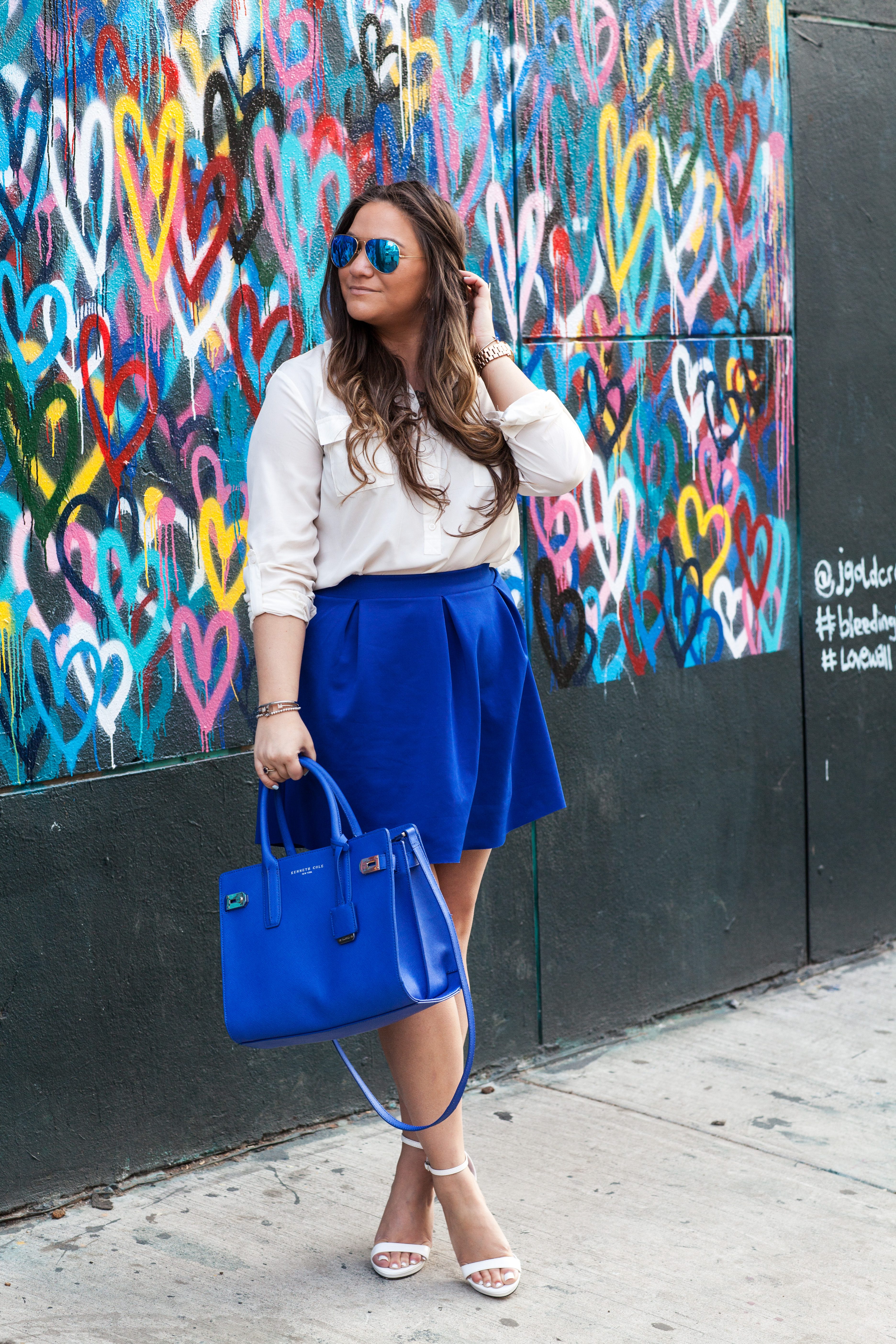 melissatierney, missyonmadison, nyc, heartwall, lovewall, graffitiart, graffiti, blueskirt, whitebuttondown, bluesatchel, mirroredaviators, whiteanklestrapsandals, raybans, springstyle, spring, streetstyle, ootd, outfitinspo, springcolors, what to wear to work in the spring,