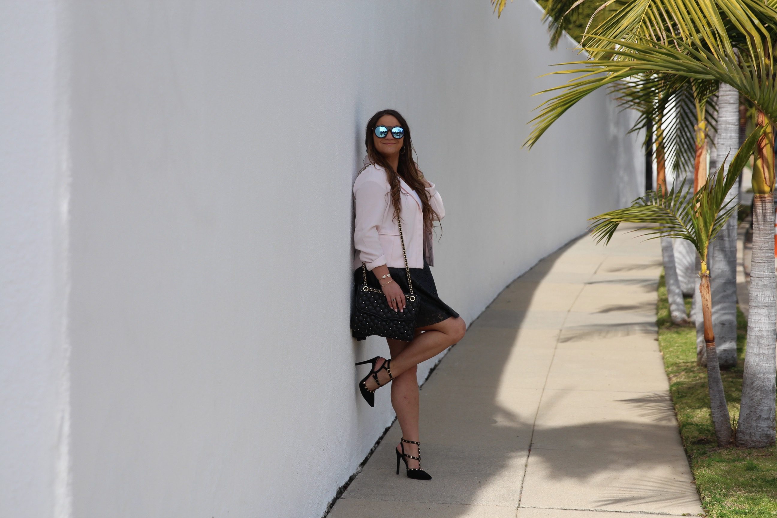 missyonmadison, fashion blog, fashion blogger, perforated skirt, black leather skirt, white crop top, white short sleeve crop top, light pink moto jacket, black studded heels, rockstud heels, look for less, le specs sunglasses, mirrored sunglasses, brunette hair, summer style, how to style a moto jacket, how to wear a leather skirt, la blogger, la style, melissa tierney,